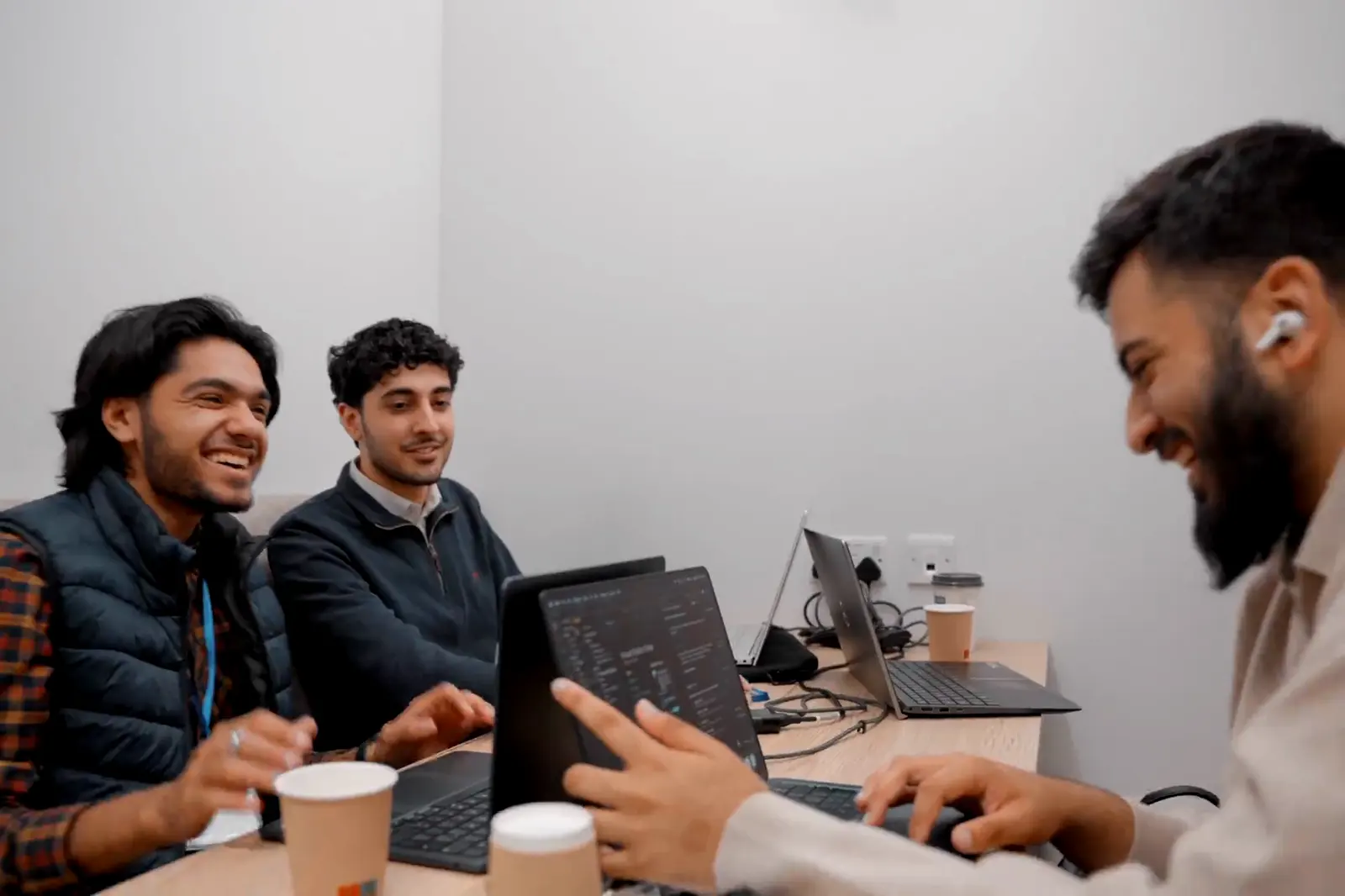 Three participants laughing together over their laptops